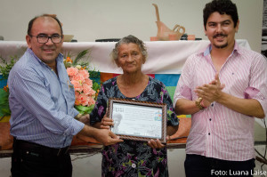 Reitor da Ufersa, professor, José de Arimatea e o diretor do filme, Francisco Bezerra, entregam homenagem a protagonista do filme, a marisqueira Terezinha de Jesus